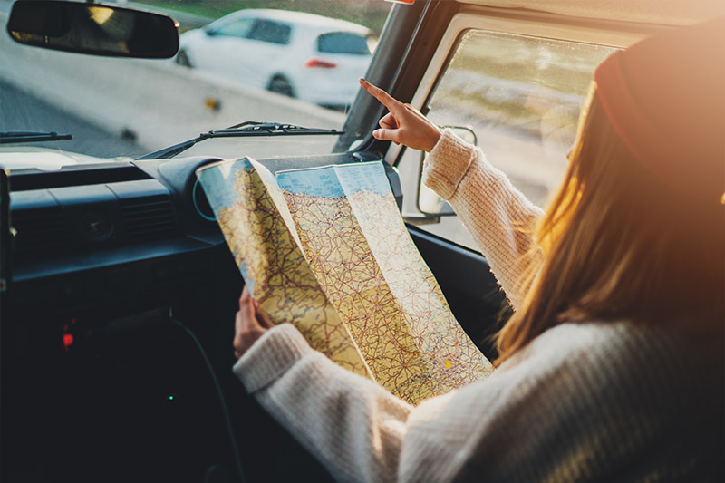 Holding a map in a car - Finding the Right Location to Buy a Home